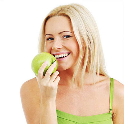 Frau beißt in Apfel